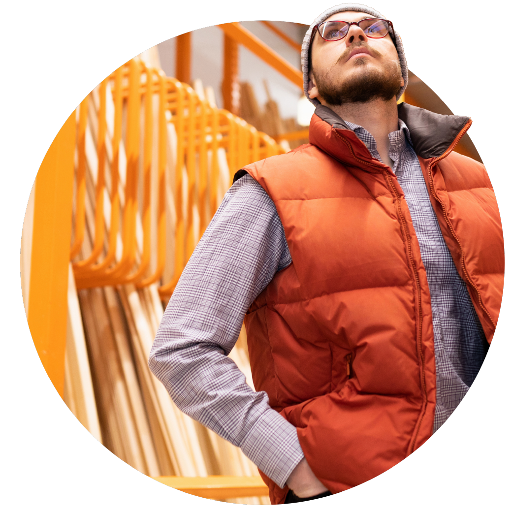 man in orange gilet looks up at products in a hardware store