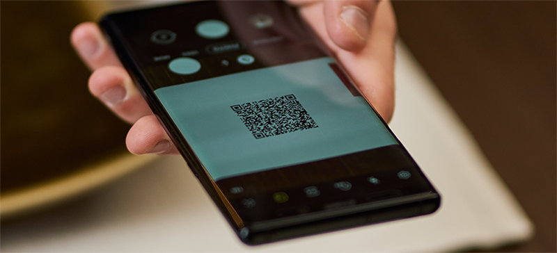 person holding phone scanning QR code